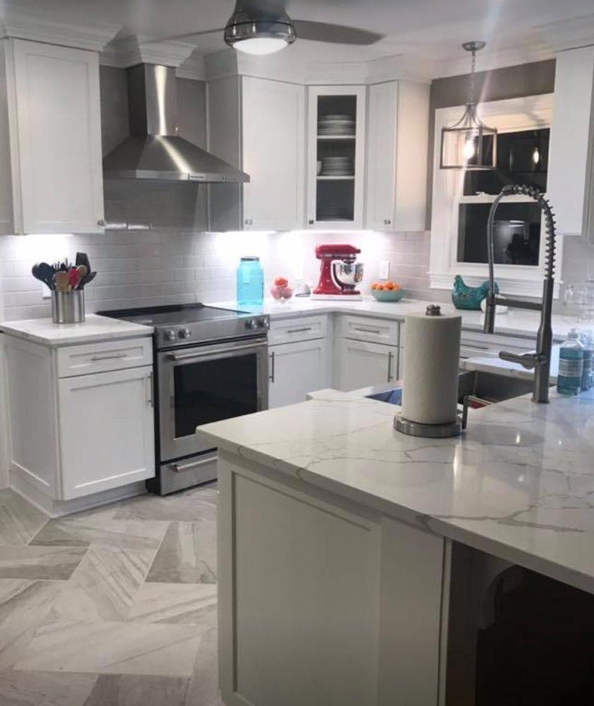 A kitchen with white cabinets and stainless steel appliances