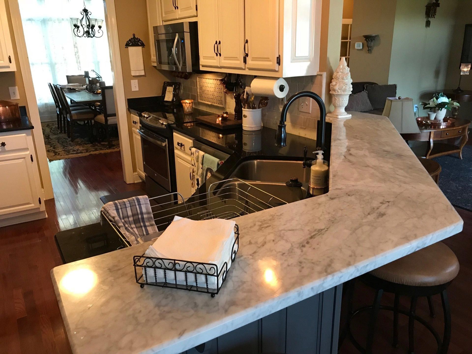 A kitchen with a marble counter top and a sink.