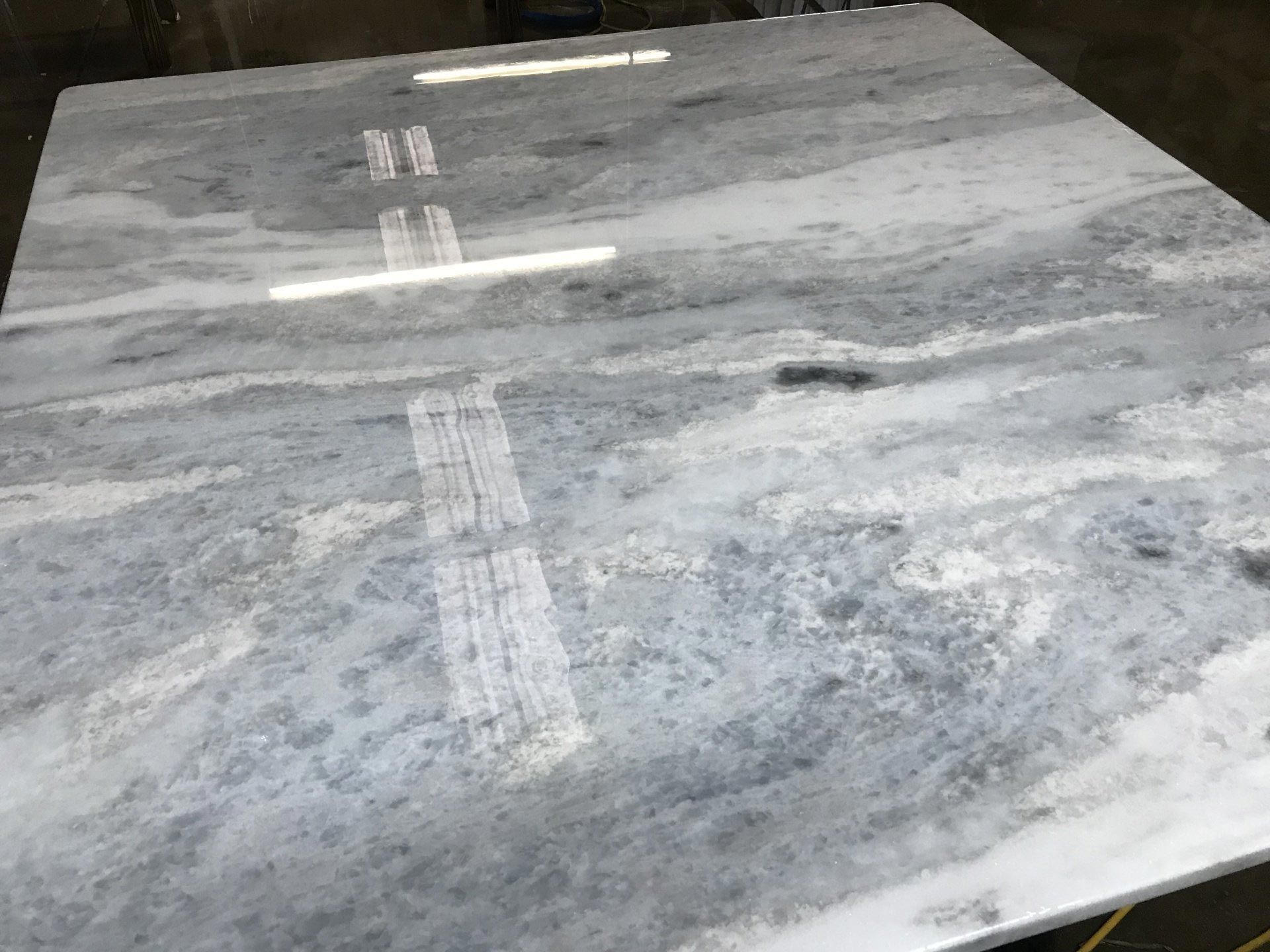 A white marble counter top is sitting on top of a wooden table.