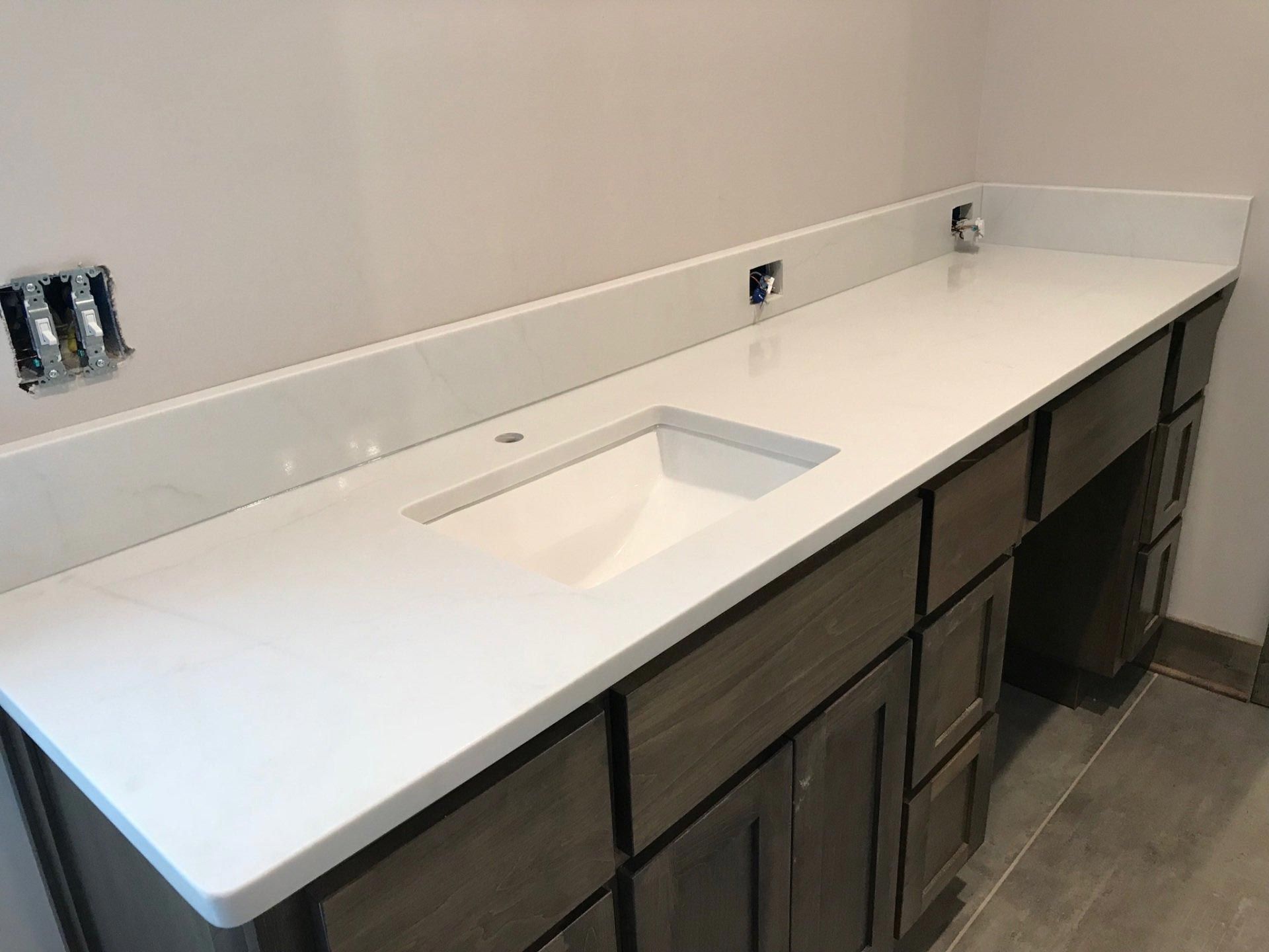 A bathroom vanity with two sinks and a white counter top.
