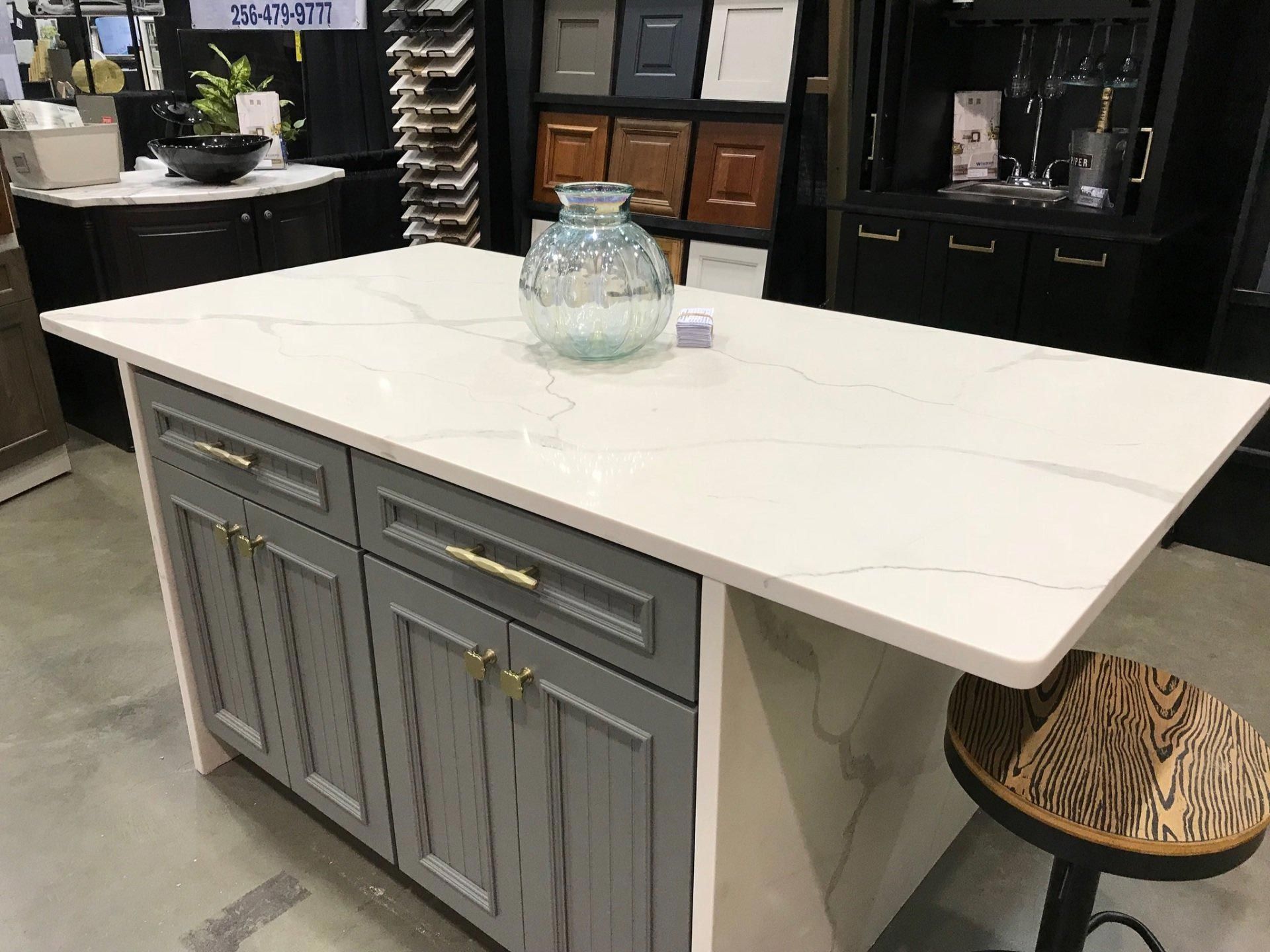 A kitchen island with a vase on top of it in a store.