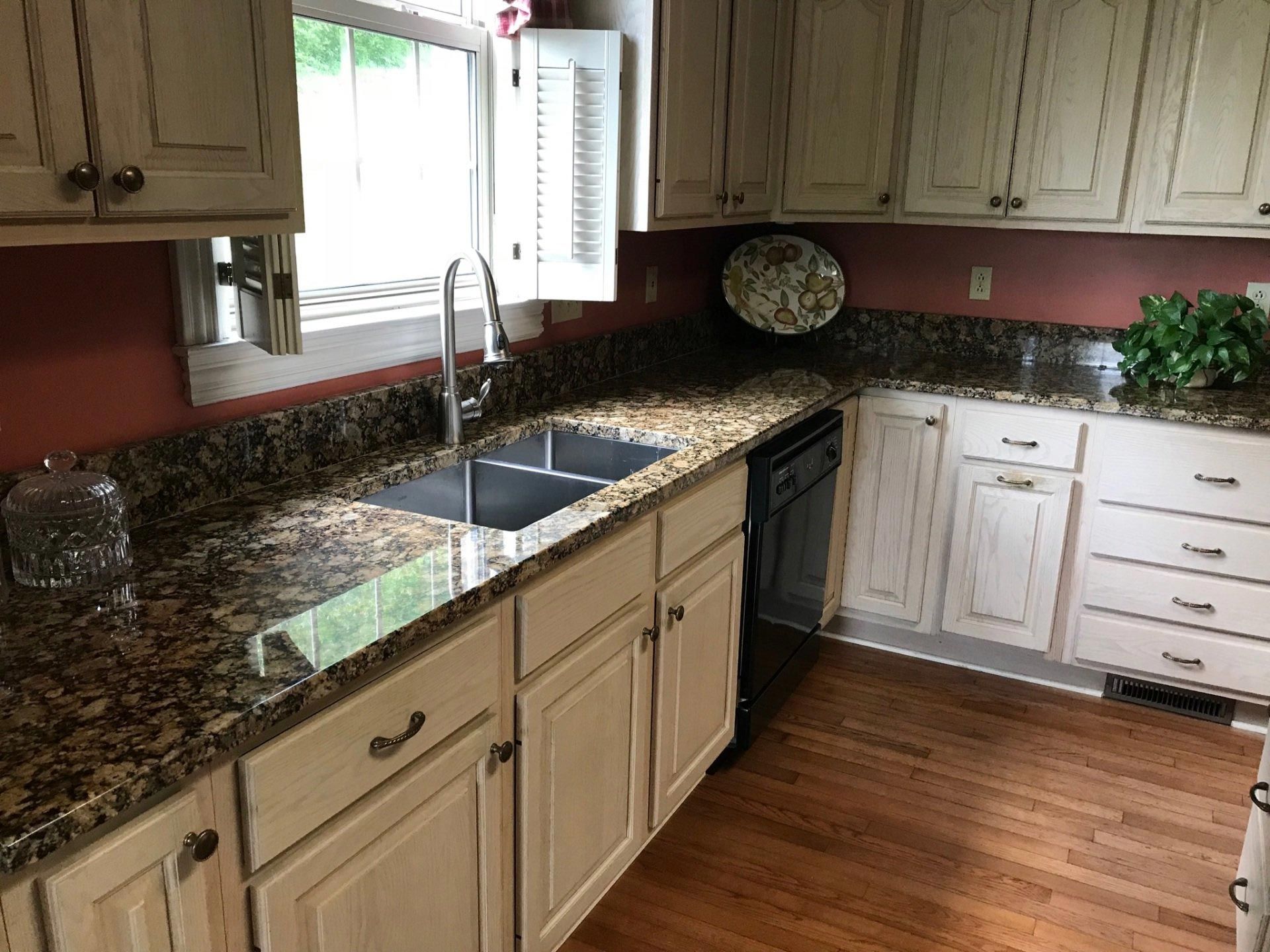 A kitchen with granite counter tops and white cabinets