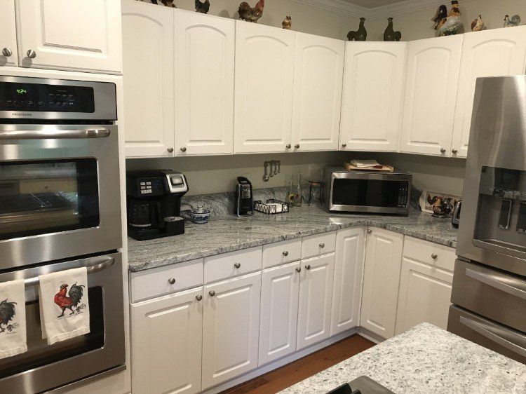 A kitchen with white cabinets and stainless steel appliances