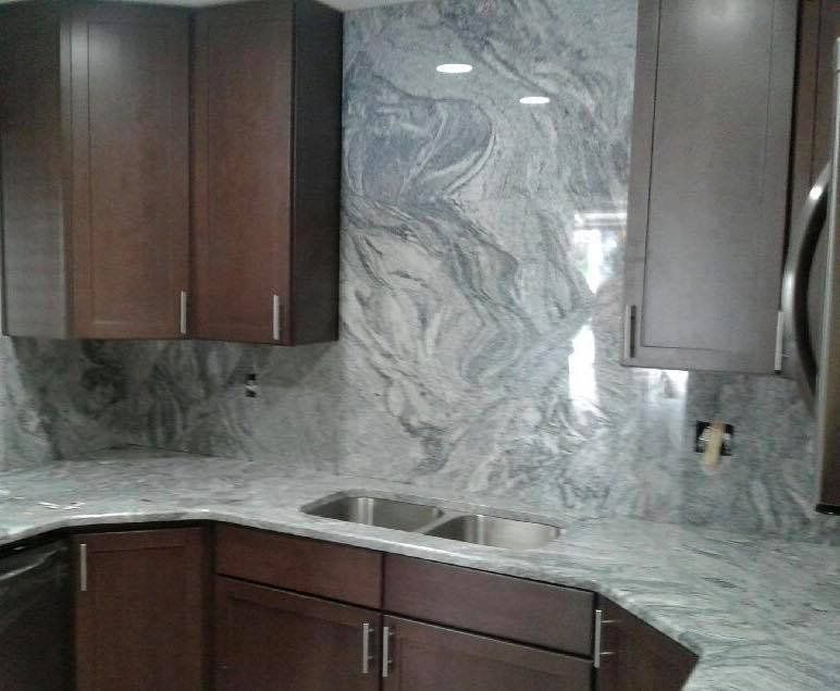 A kitchen with marble counter tops and wooden cabinets