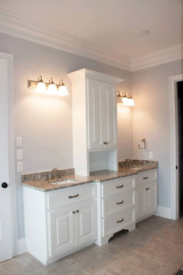 A bathroom with two sinks and a dresser.