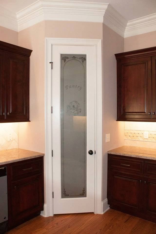 A kitchen with dark wood cabinets and a white door
