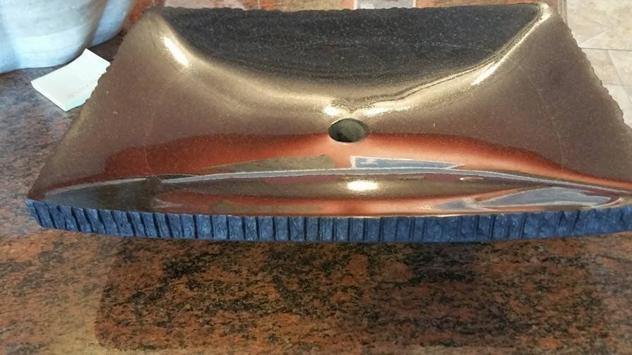 A metal object is sitting on a granite counter top.