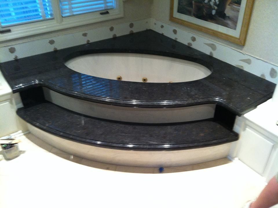 A bathtub with steps leading up to it in a bathroom