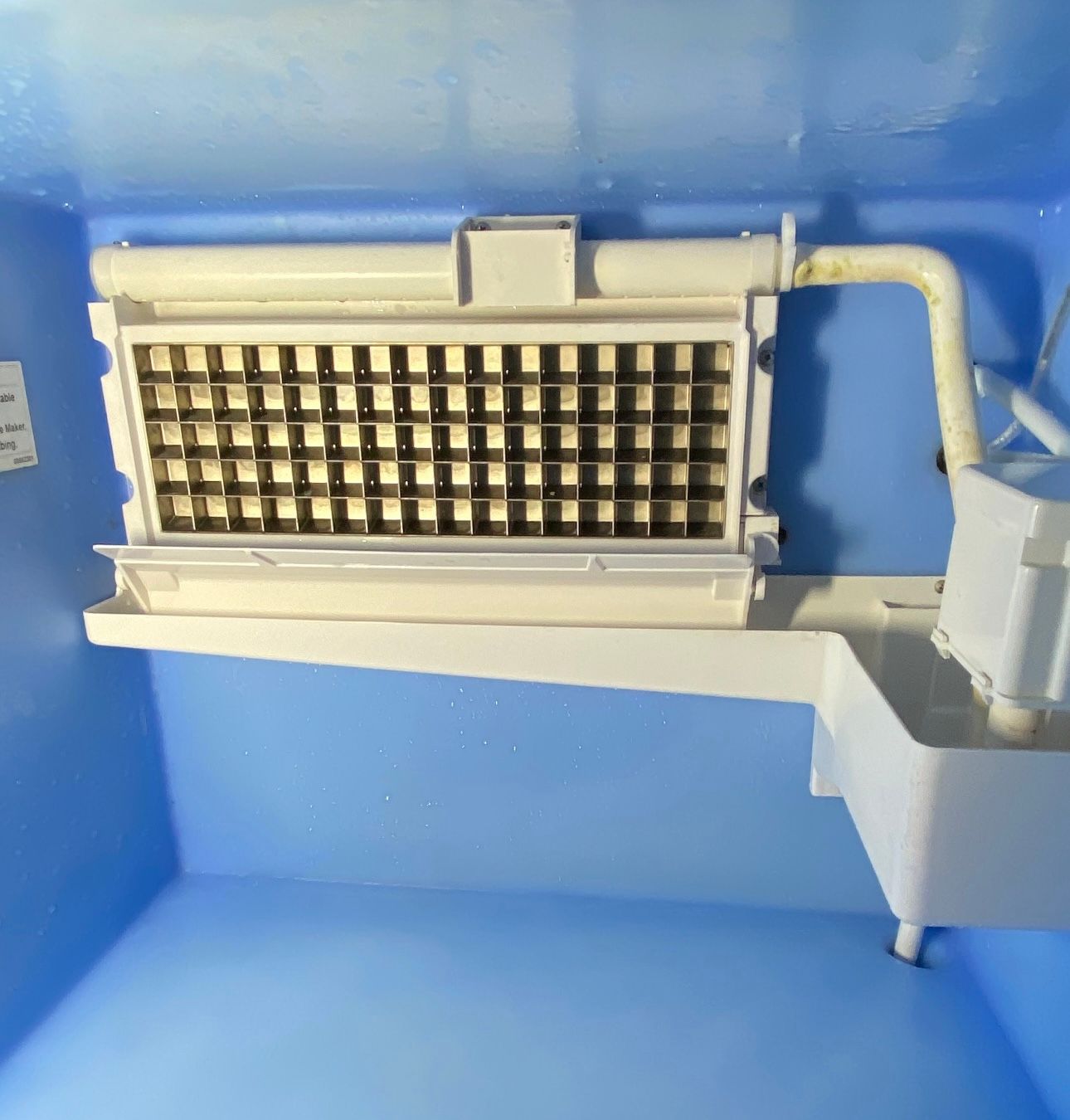 a white ice maker is sitting in a blue box