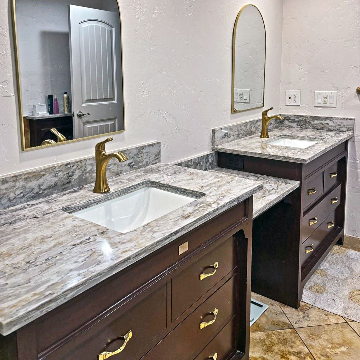 Modern bathroom with a soaking tub, double sinks, and a stone-like accent wall.