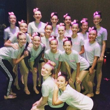 A group of young girls are holding red hearts that say love hope respect family faith pride.