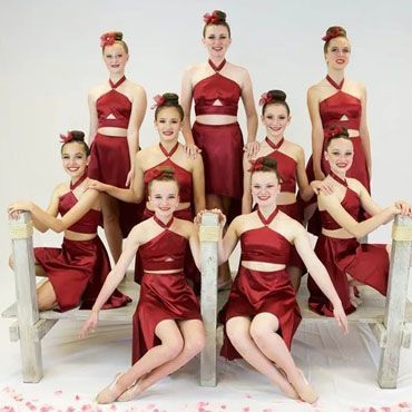 A group of young women in red dresses are posing for a picture