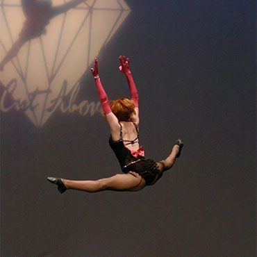 A woman in red gloves is jumping in the air