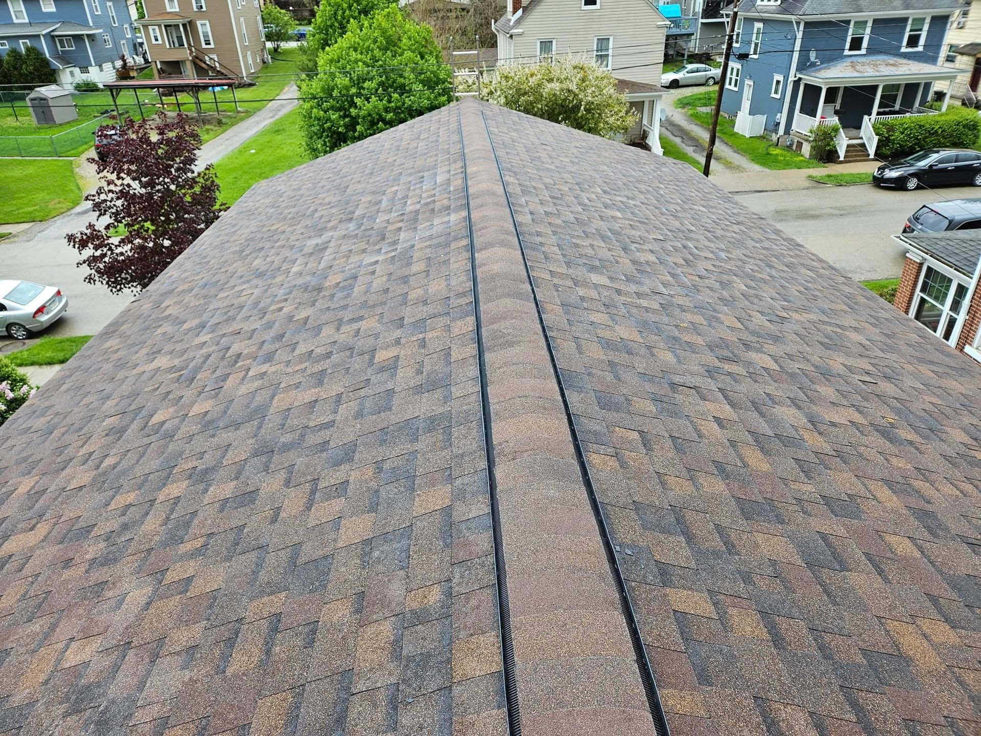An aerial view of a roof with a row of houses in the background.