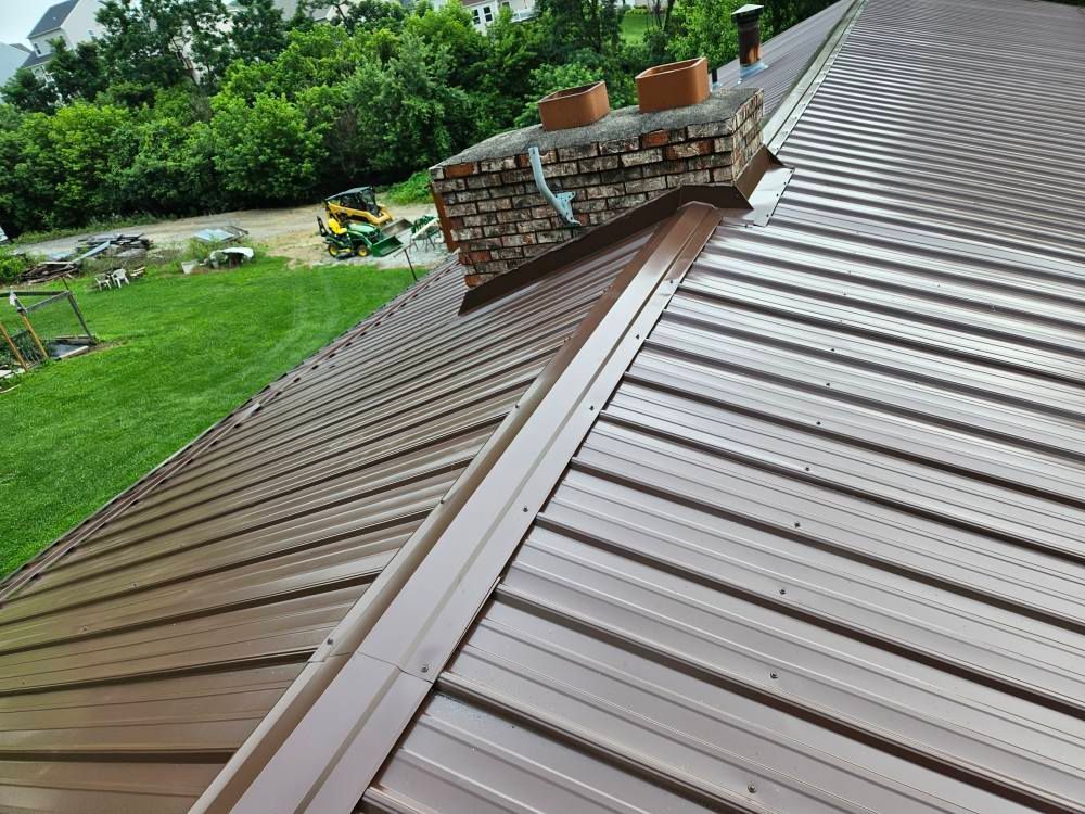 A brown metal roof with a chimney on top of it
