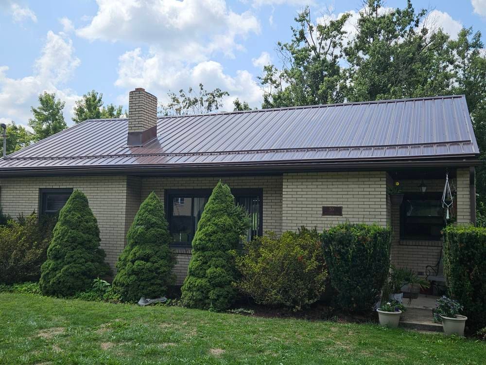 A brick house with a metal roof and a chimney