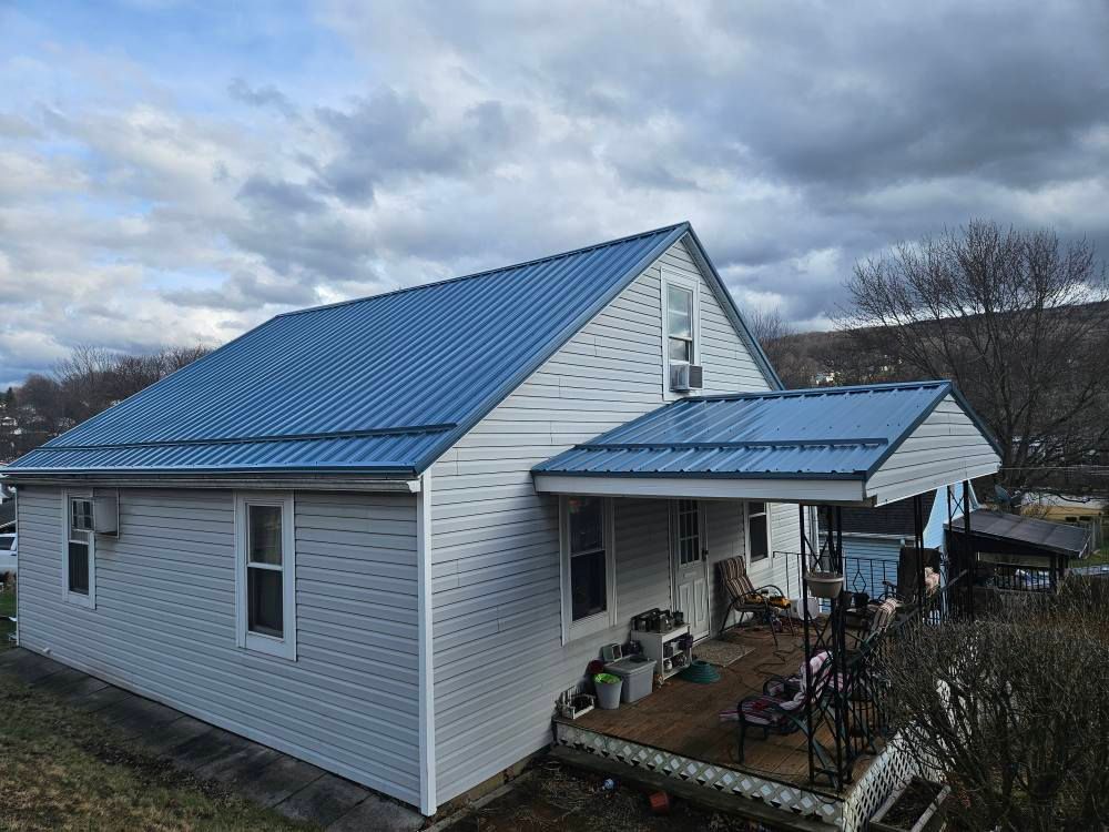 A white house with a blue roof and a porch.