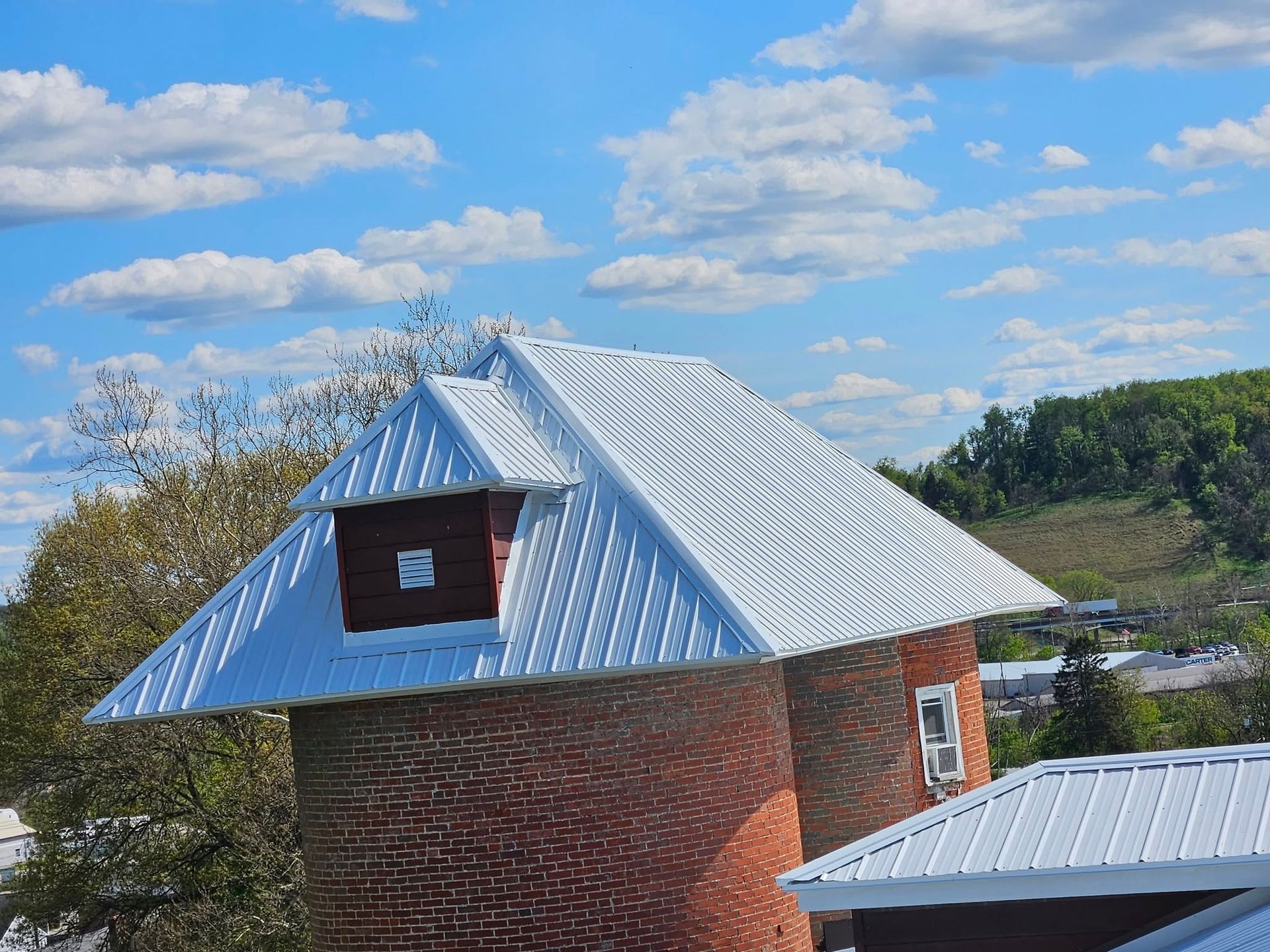 A brick building with a white roof and a chimney on top of it.