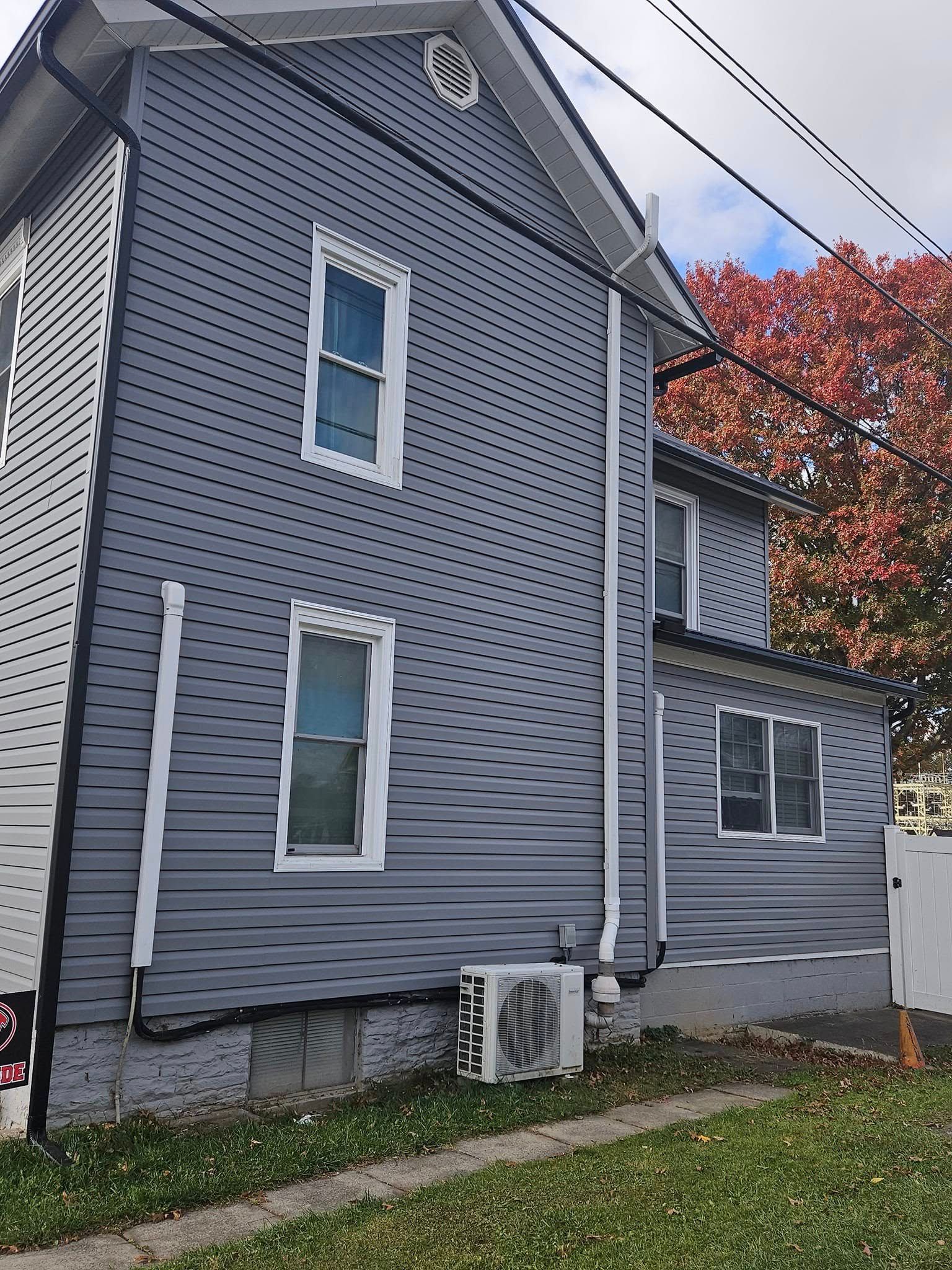 A gray and white house with a lot of windows is for sale.