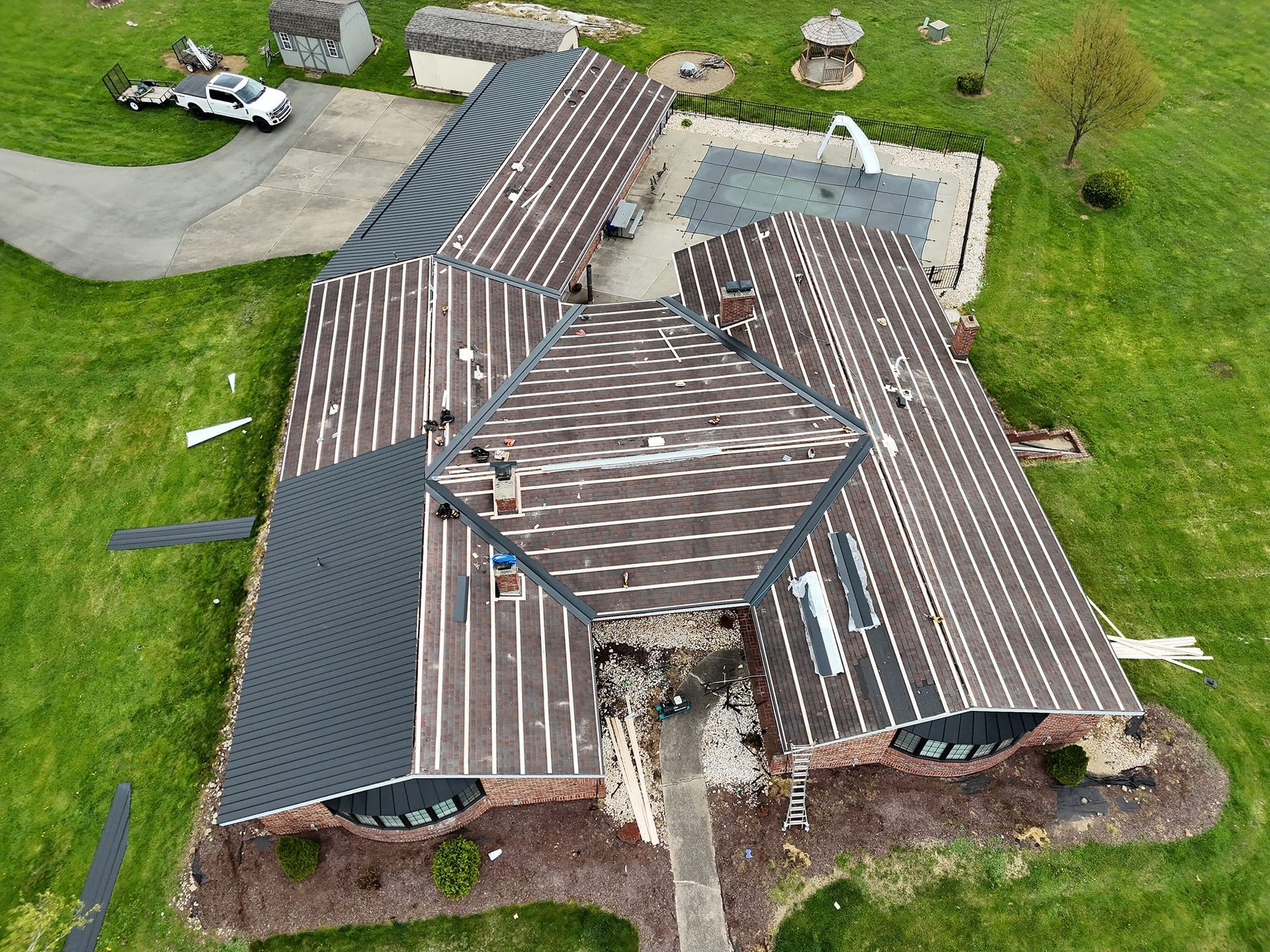 An aerial view of a large house with a roof that is being installed.