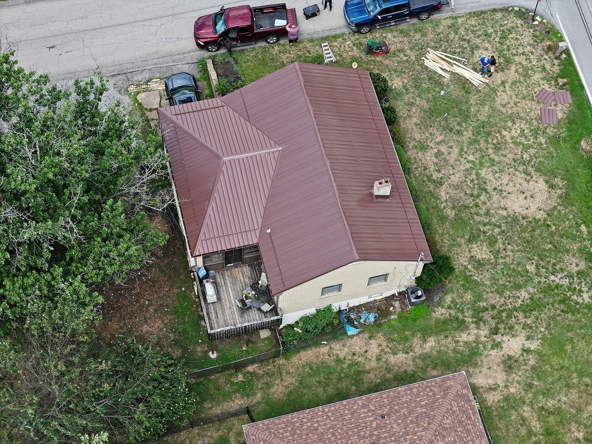An aerial view of a house with a brown roof in a residential area.
