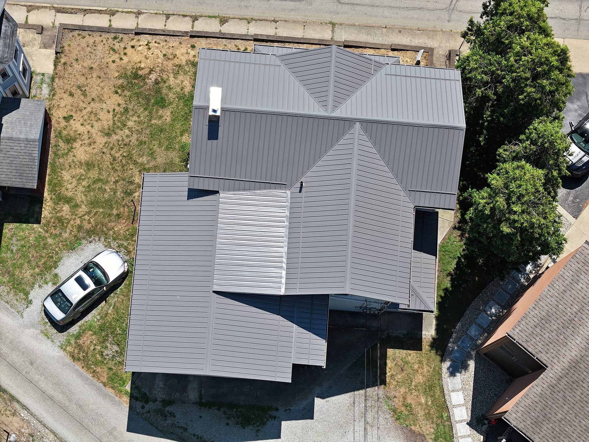 An aerial view of a house with a car parked in front of it