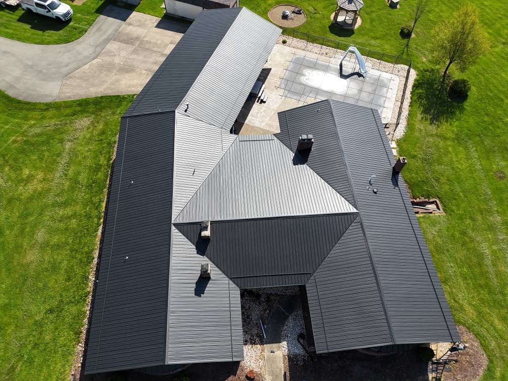 An aerial view of a house with a black roof.
