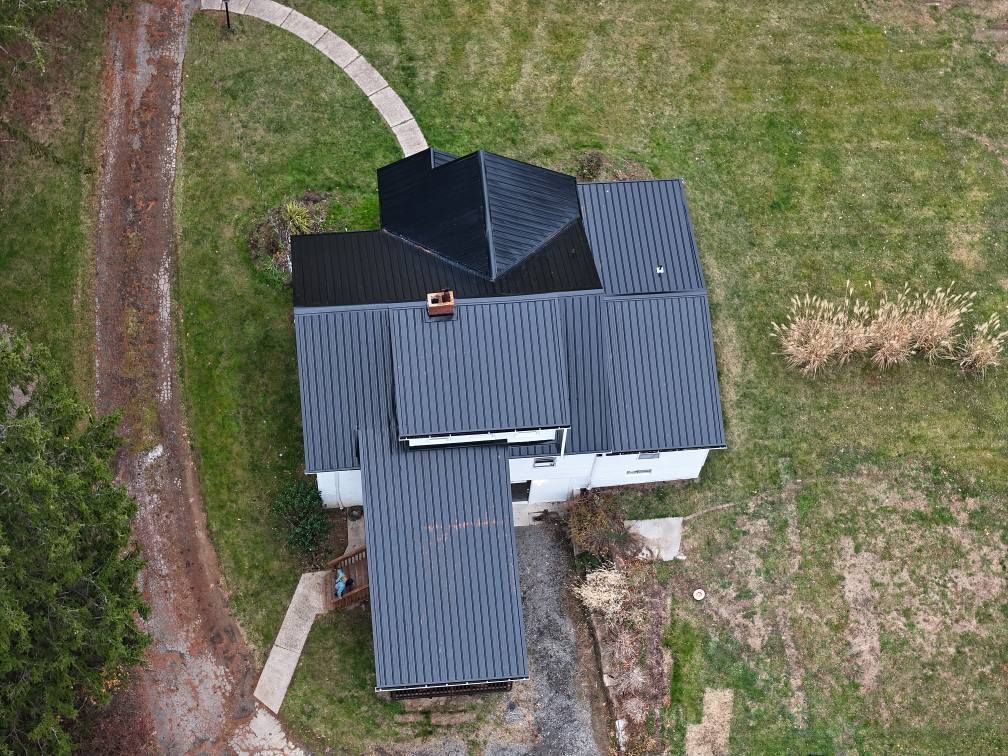 An aerial view of a house with a black roof