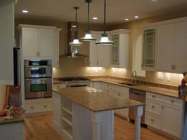 A kitchen with white cabinets and granite counter tops
