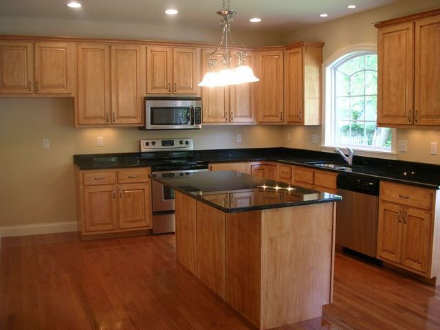 A kitchen with stainless steel appliances and wooden cabinets