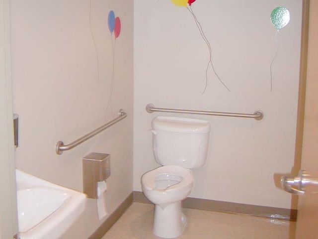 A bathroom with a toilet and balloons on the wall