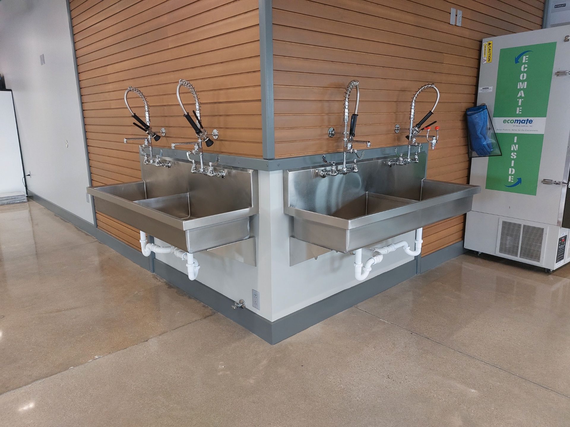 A row of stainless steel sinks in a hallway