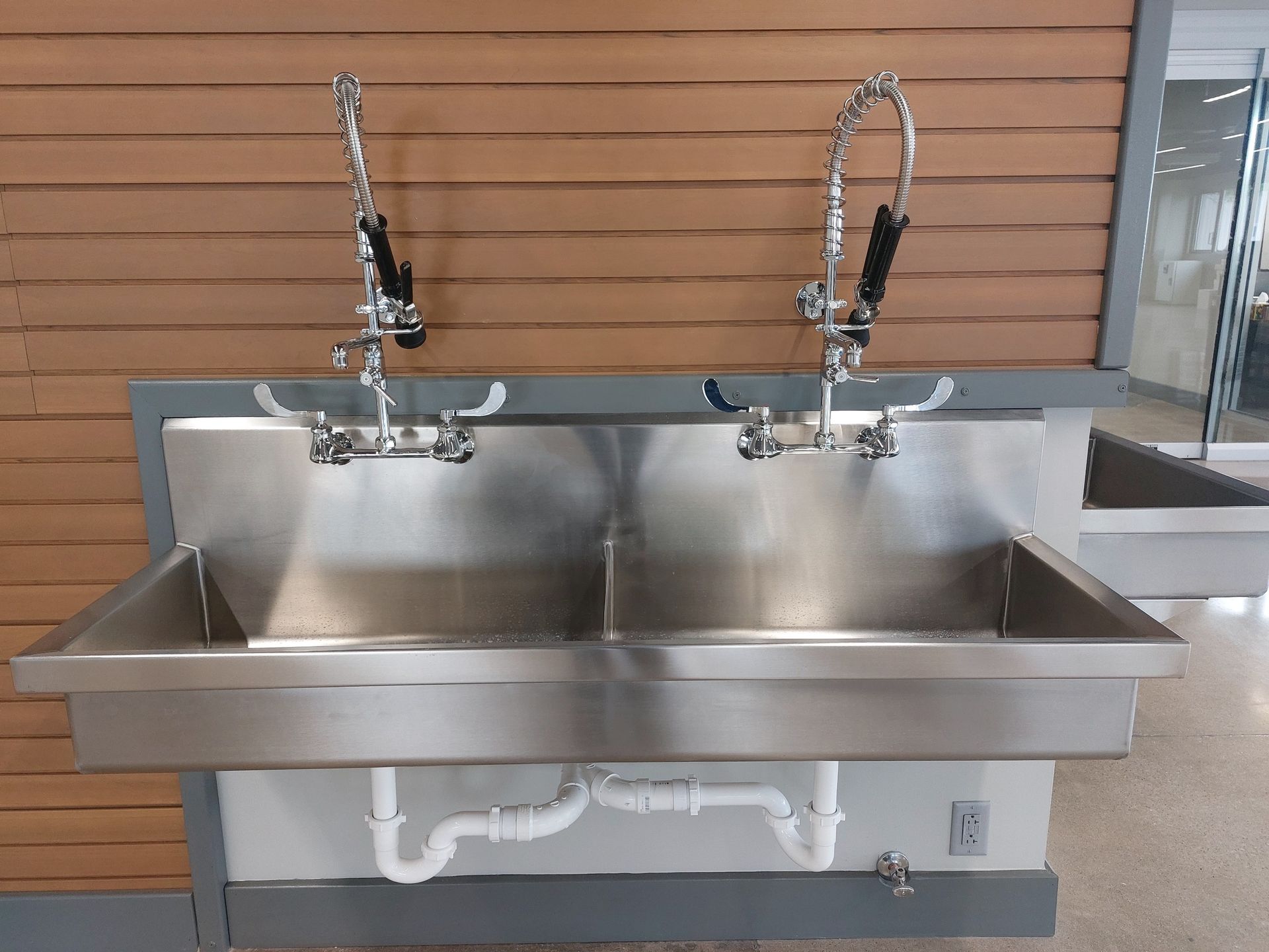 A stainless steel sink with two faucets attached to it