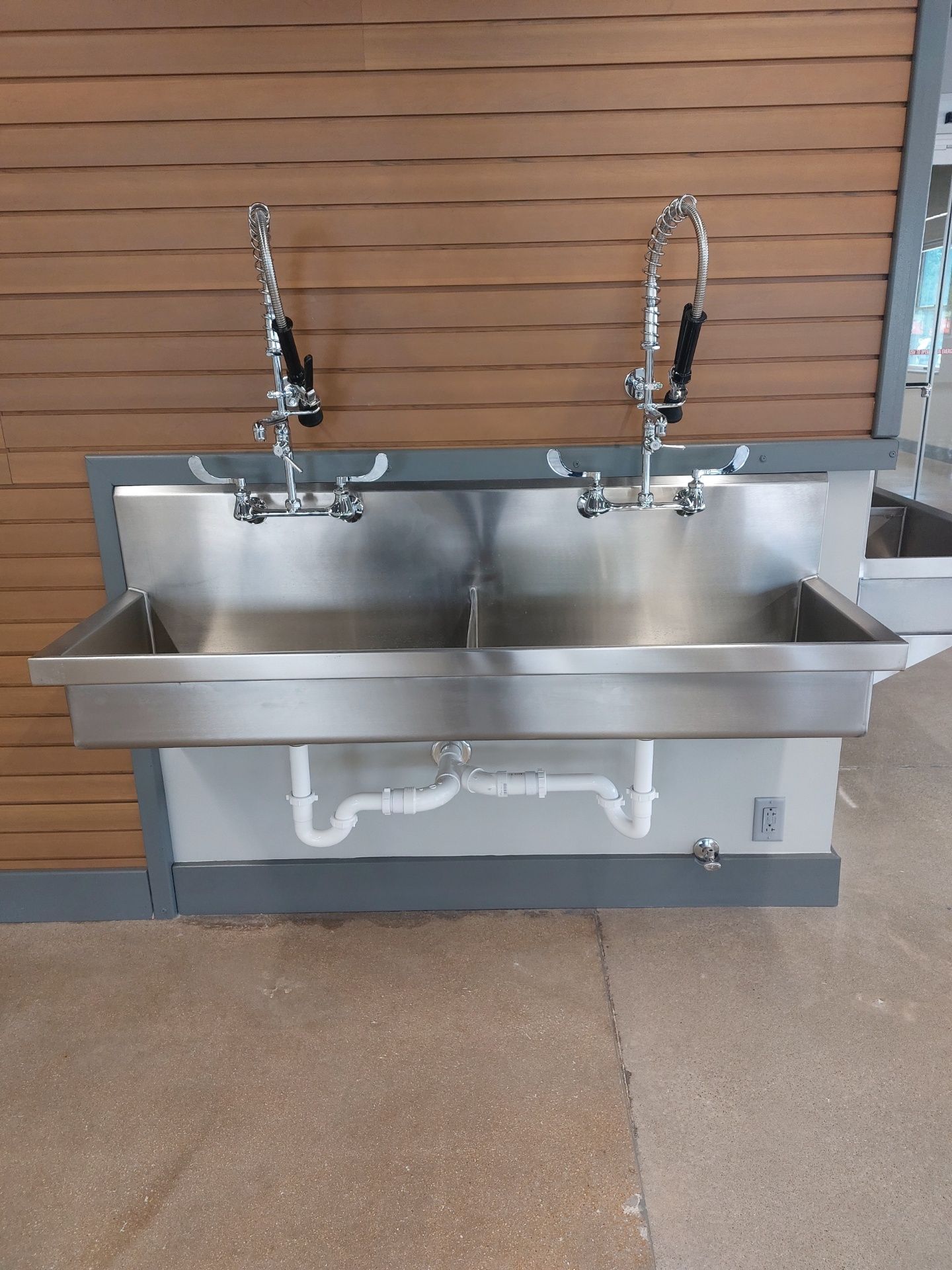 Two stainless steel sinks are hanging on a wall.