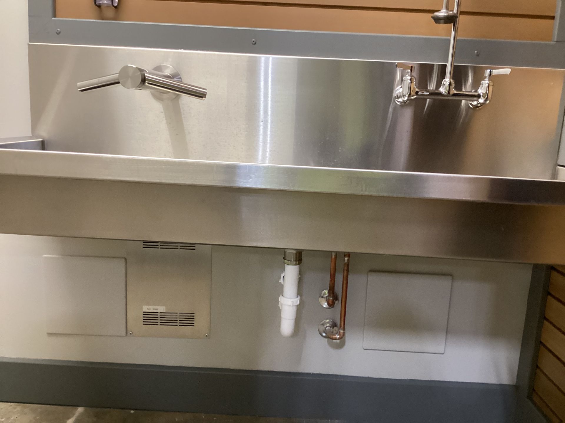 A stainless steel sink in a bathroom with a faucet