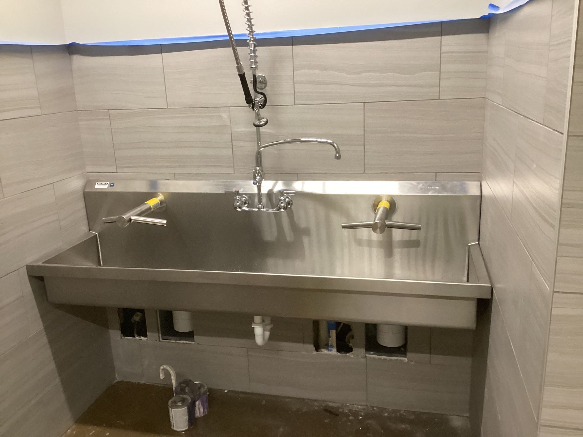 A stainless steel sink in a bathroom under construction