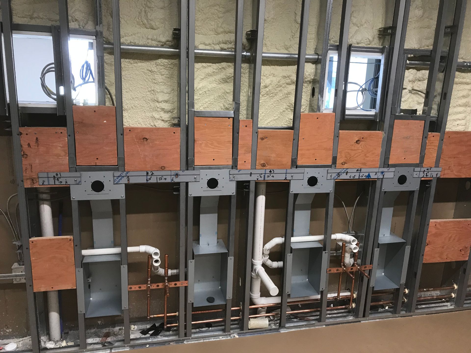 A wall with a lot of pipes coming out of it.