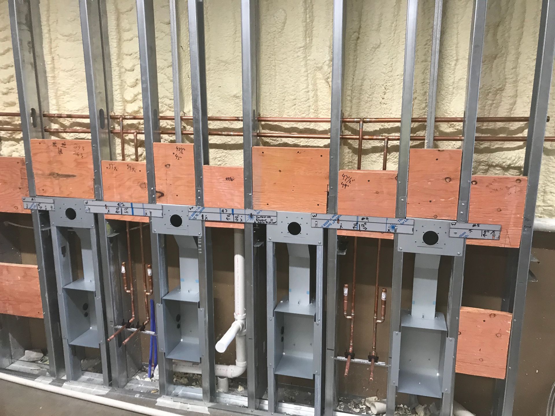 A wall with a lot of pipes coming out of it is being built.