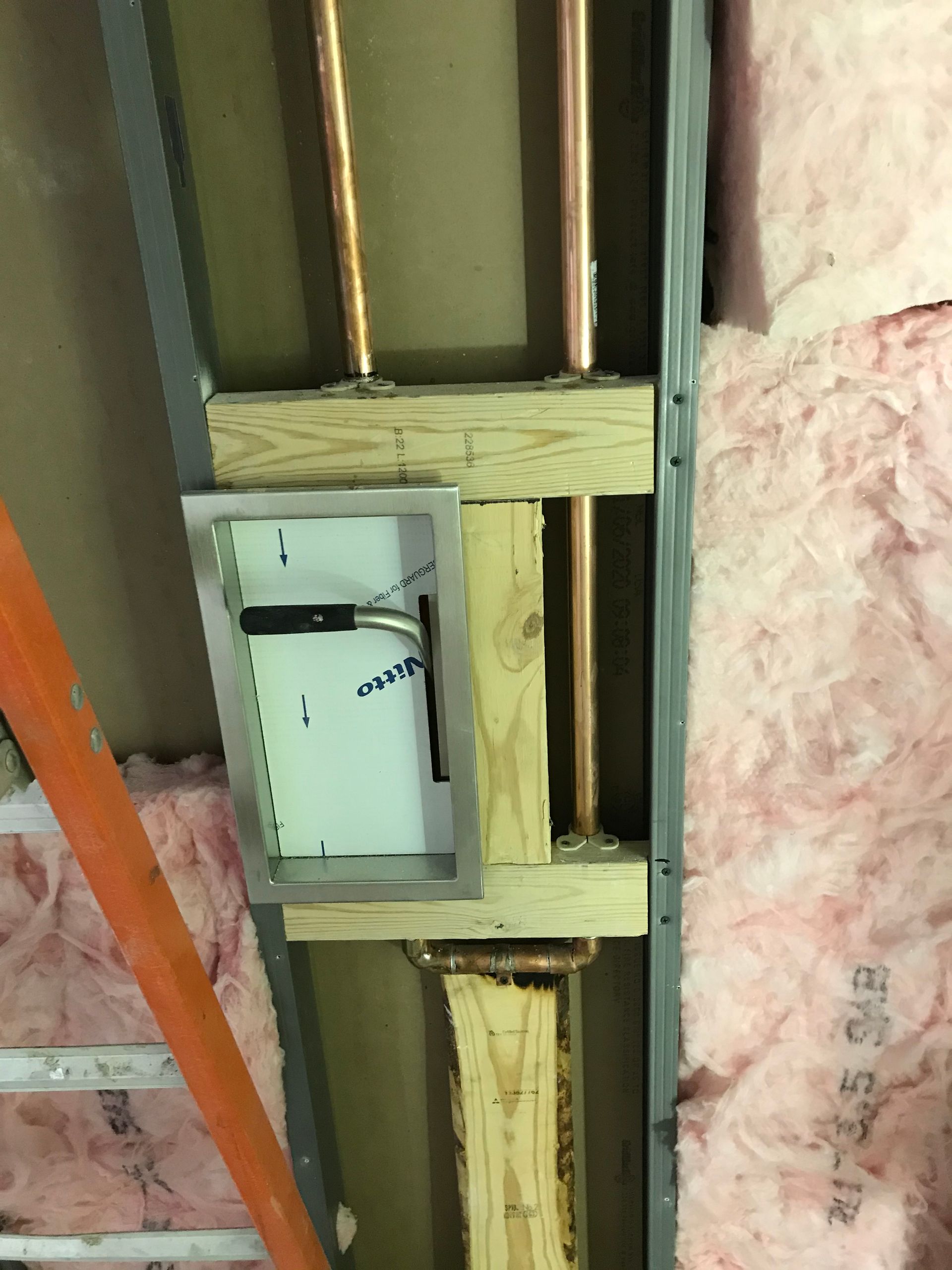 A ladder is hanging from the ceiling next to a copper pipe