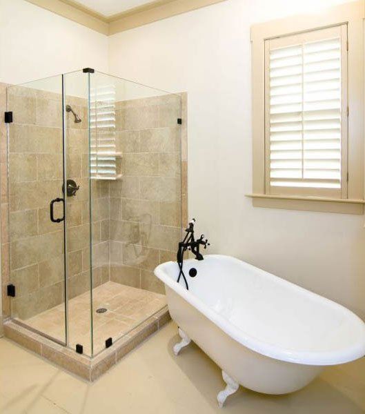 A bathroom with a tub and a walk in shower