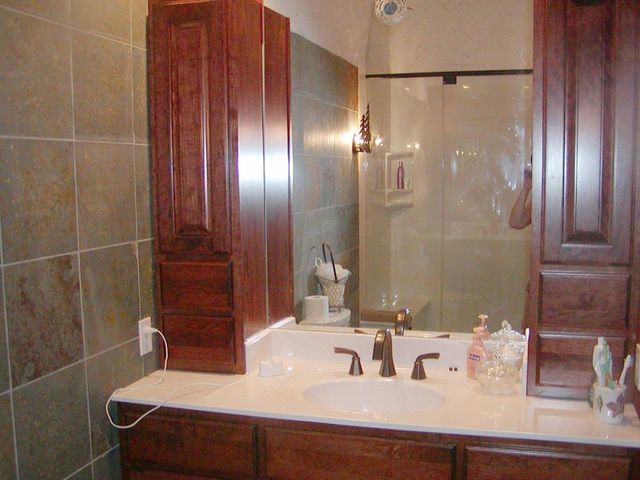 A bathroom with a sink , mirror and cabinets