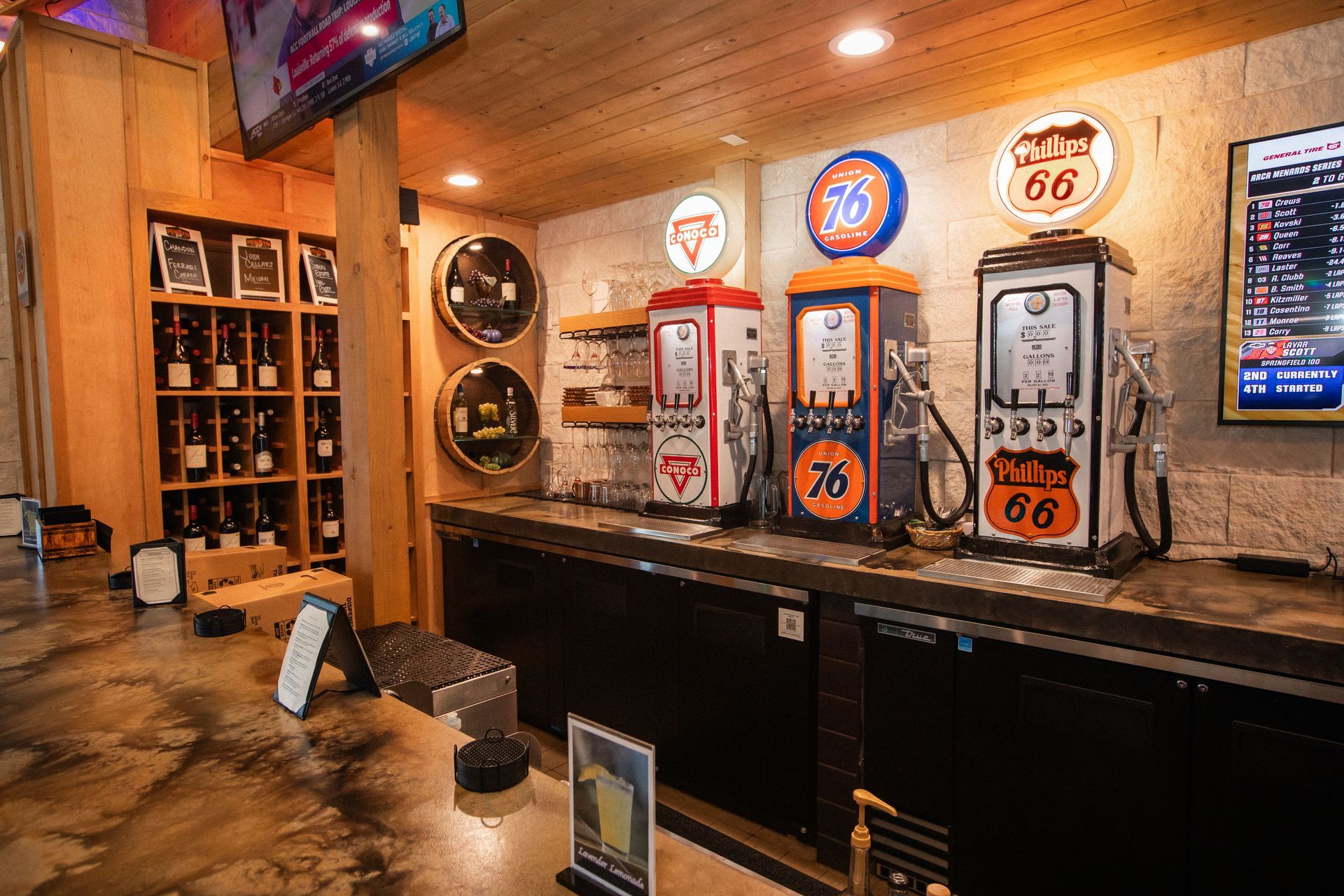 Bar with retro gas pump decor and liquor bottles on shelves.