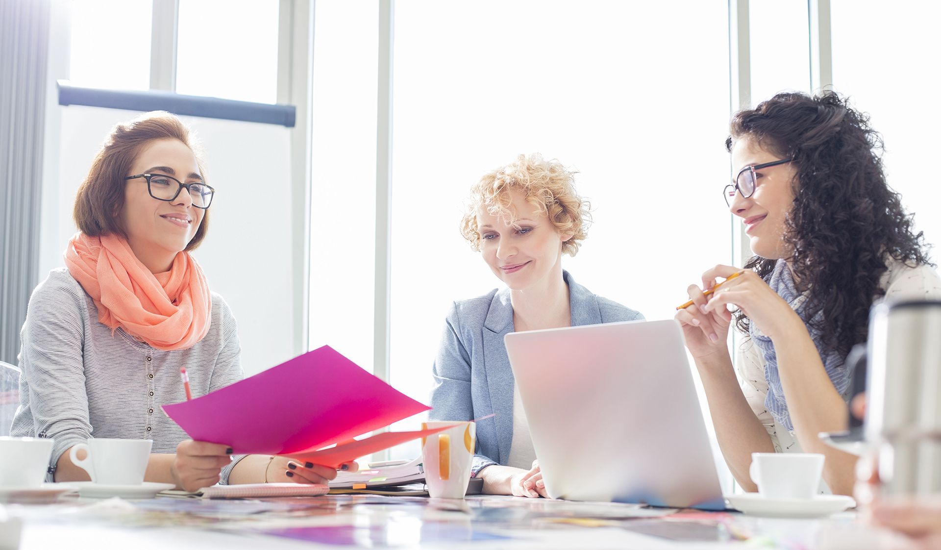 A utility room with two boilers, a water heater, and piping, against beige walls and a white ceiling.