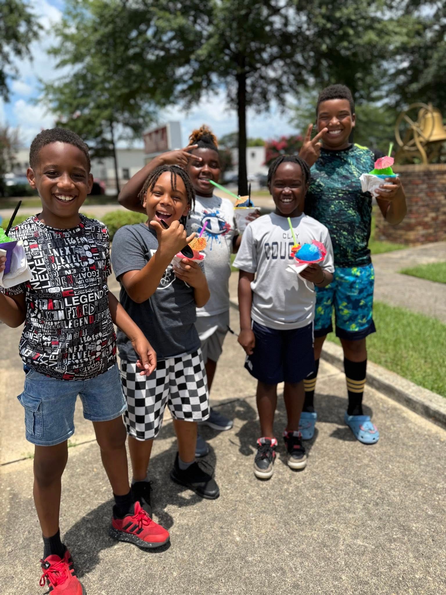 Group of children with shaved ice, smiling outside.