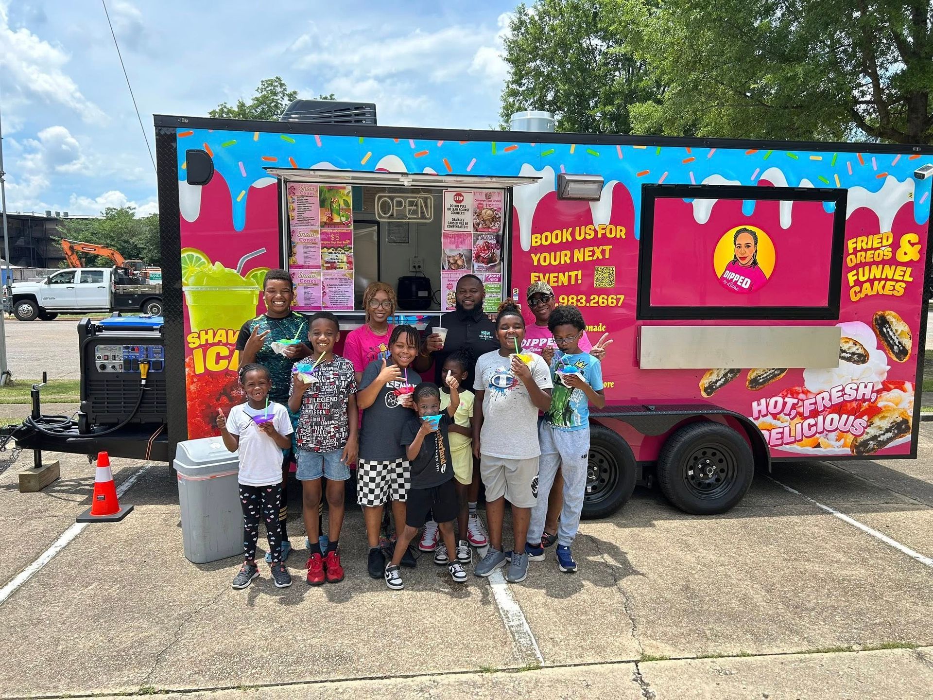 Group of people smiling with ice cream bars in front of a colorful food trailer.