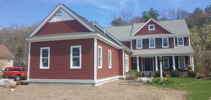 Red-sided house with white trim and a red pickup truck on the left.