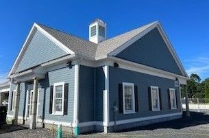 Blue building with white trim and a small cupola against a blue sky.
