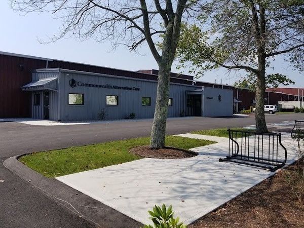 Exterior view of Commonwealth Aviation Center building with bike rack and trees.