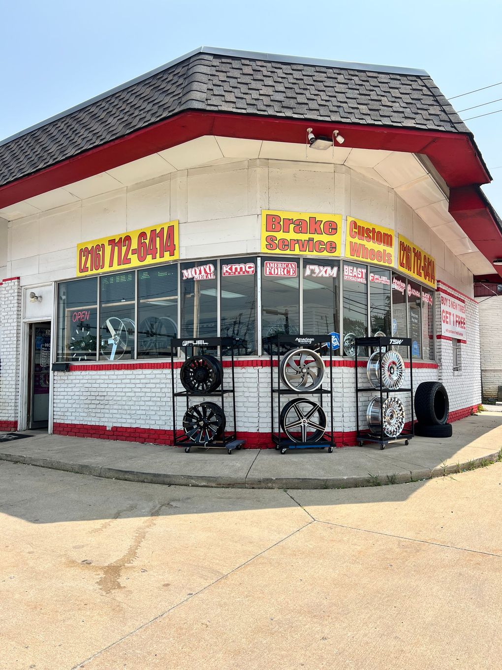 A tire shop with a lot of tires on display in front of it.