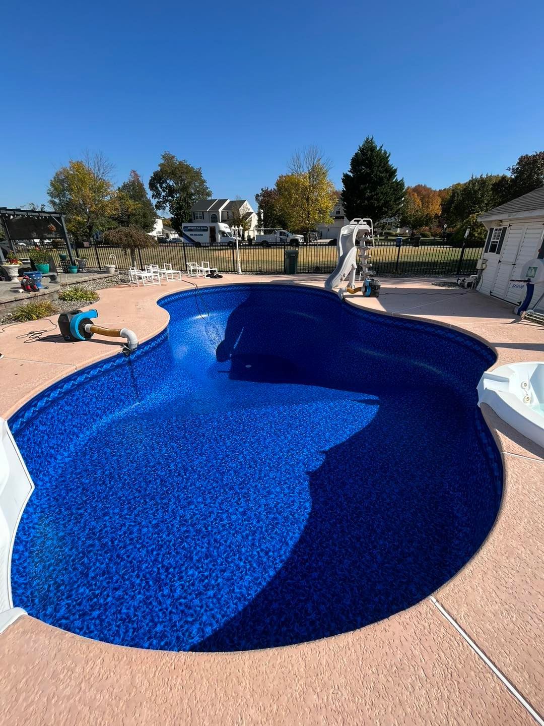 A large blue swimming pool is being built in a backyard.